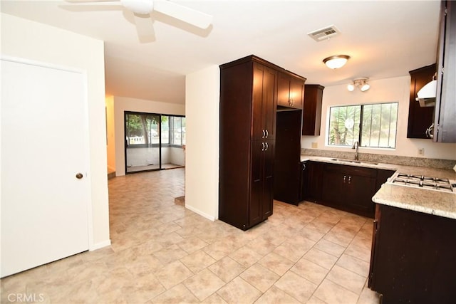 1069 Donahue St, San Diego, CA 92110 - kitchen with plenty of natural light, under cabinet range hood, a ceiling fan, and dark brown cabinets