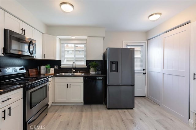 19847 Coventry Ln, Huntington Beach, CA 92646 - kitchen featuring stainless steel appliances, dark countertops, light wood-style flooring, and white cabinets