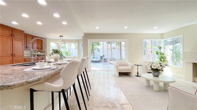 4 Salerno, Irvine, CA 92614 - kitchen with recessed lighting, a kitchen breakfast bar, brown cabinets, pendant lighting, and light stone counters