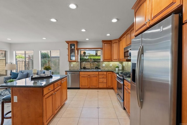 21905 Grovepark Dr, Saugus, CA 91350 - kitchen featuring appliances with stainless steel finishes, a sink, backsplash, brown cabinets, and recessed lighting