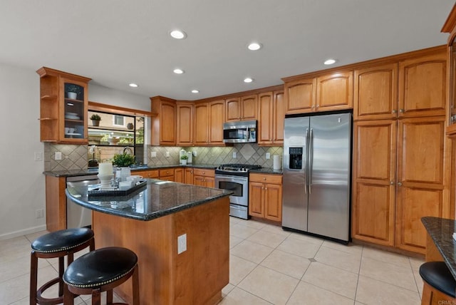 21905 Grovepark Dr, Saugus, CA 91350 - kitchen with appliances with stainless steel finishes, brown cabinetry, dark stone countertops, decorative backsplash, and recessed lighting