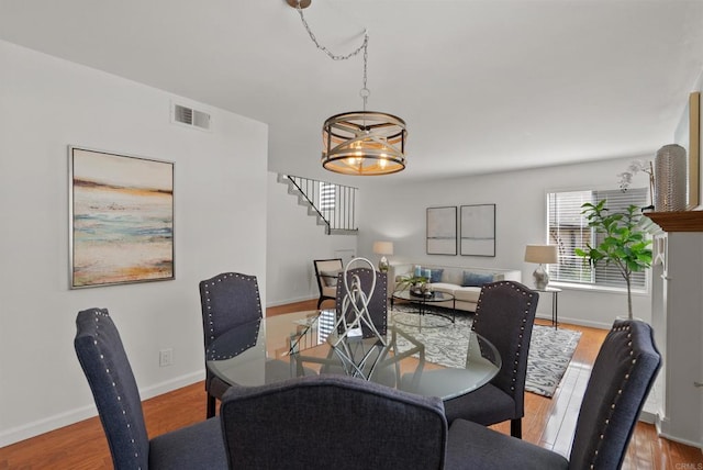 21905 Grovepark Dr, Saugus, CA 91350 - dining room featuring stairs, wood finished floors, and a chandelier