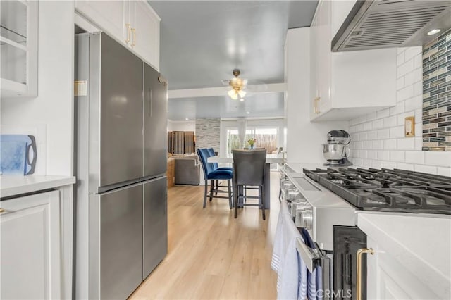 534 E Hazel St Unit 5, Inglewood, CA 90302 - kitchen featuring stainless steel appliances, custom range hood, light wood-style flooring, and white cabinetry