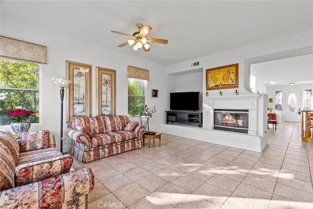22440 Skylake Pl, Saugus, CA 91390 - living area featuring ceiling fan, healthy amount of natural light, light tile patterned floors, and a glass covered fireplace