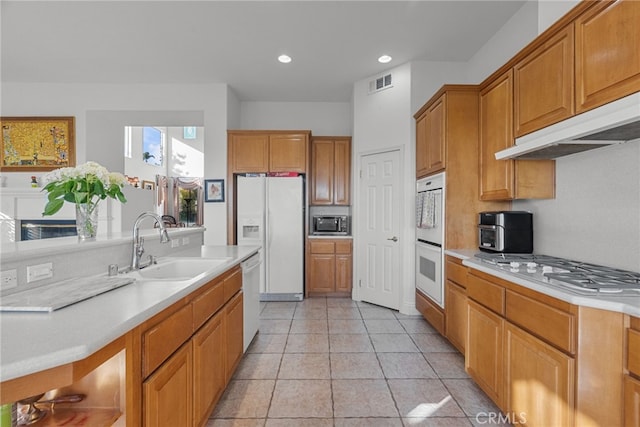 22440 Skylake Pl, Saugus, CA 91390 - kitchen featuring appliances with stainless steel finishes, light countertops, a sink, brown cabinetry, and recessed lighting