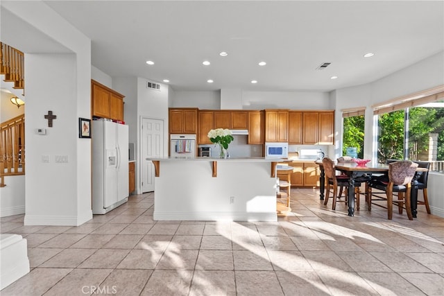 22440 Skylake Pl, Saugus, CA 91390 - kitchen featuring white appliances, light countertops, recessed lighting, baseboards, and a kitchen breakfast bar