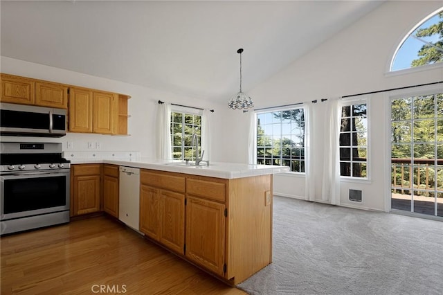 26350 Spyglass Dr, Lake Arrowhead, CA 92352 - kitchen with stainless steel appliances, a peninsula, a sink, plenty of natural light, and high vaulted ceiling