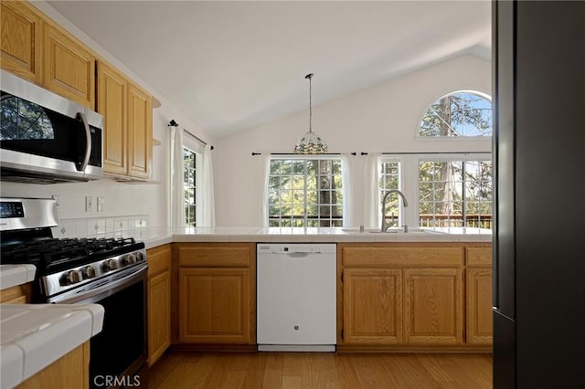 26350 Spyglass Dr, Lake Arrowhead, CA 92352 - kitchen featuring stainless steel appliances, a sink, vaulted ceiling, healthy amount of natural light, and light wood finished floors