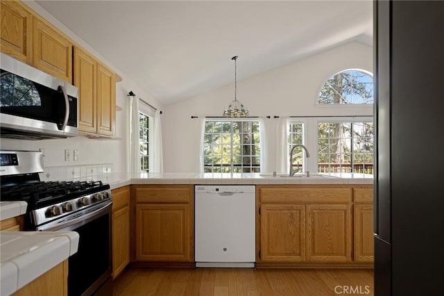 26350 Spyglass Dr, Lake Arrowhead, CA 92352 - kitchen featuring stainless steel appliances, lofted ceiling, healthy amount of natural light, light wood-type flooring, and tile counters