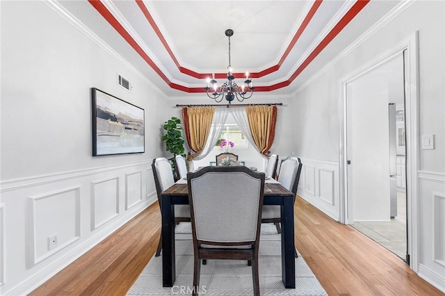 338 Laurel Ave, Arcadia, CA 91006 - dining area with a raised ceiling, a chandelier, light wood-style flooring, a decorative wall, and crown molding