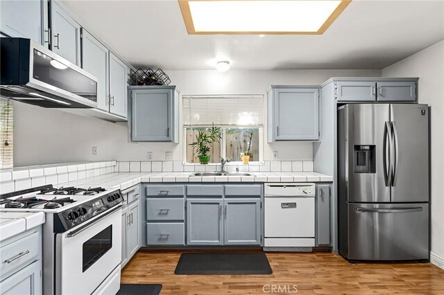 258 Vail Dr, Chico, CA 95973 - kitchen with appliances with stainless steel finishes, a sink, light wood finished floors, and gray cabinets