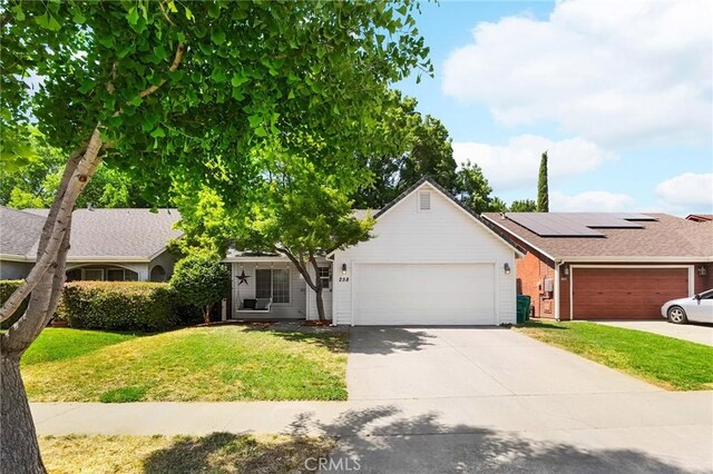 258 Vail Dr, Chico, CA 95973 - view of front facade featuring an attached garage, a front yard, driveway, and roof mounted solar panels