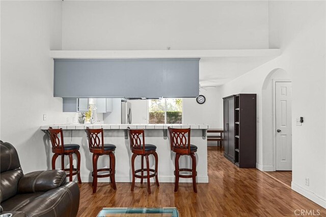 258 Vail Dr, Chico, CA 95973 - kitchen featuring tile counters, open floor plan, a breakfast bar, and wood finished floors