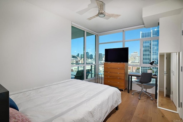 325 7th Unit 1501, San Diego, CA 92101 - bedroom with expansive windows, hardwood / wood-style flooring, a desk, and a ceiling fan