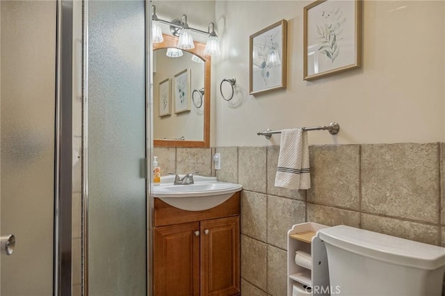 31297 All View Dr, Running Springs, CA 92382 - full bathroom with vanity, toilet, a shower stall, tile walls, and a wainscoted wall