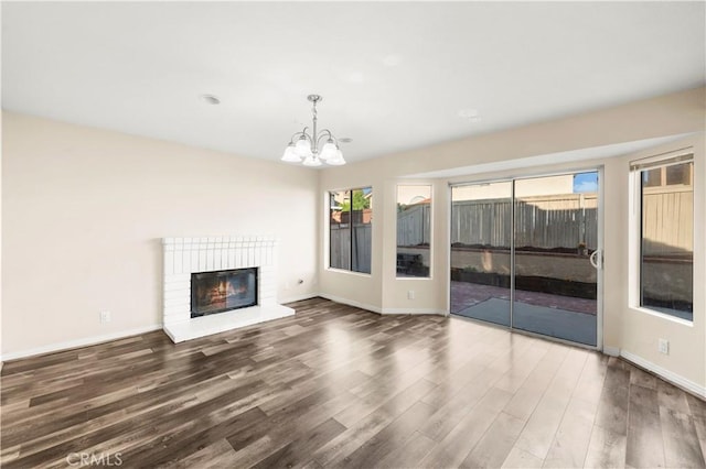 30470 Bayport Ln, Menifee, CA 92584 - unfurnished living room with wood finished floors, a chandelier, a brick fireplace, and baseboards