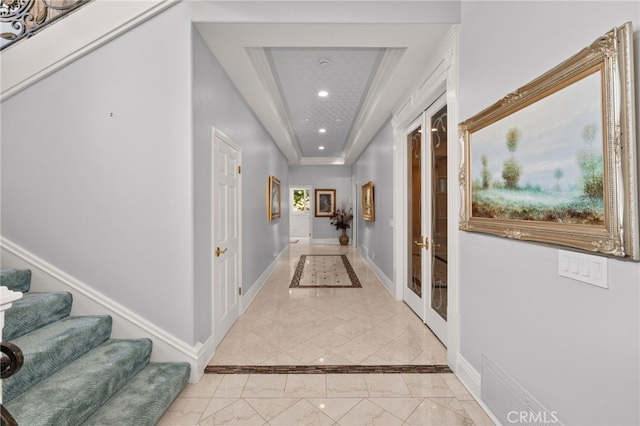 8790 King Ranch Rd, Rancho Cucamonga, CA 91701 - hallway featuring recessed lighting, french doors, inlaid floor details, light marble finish flooring, and a tray ceiling