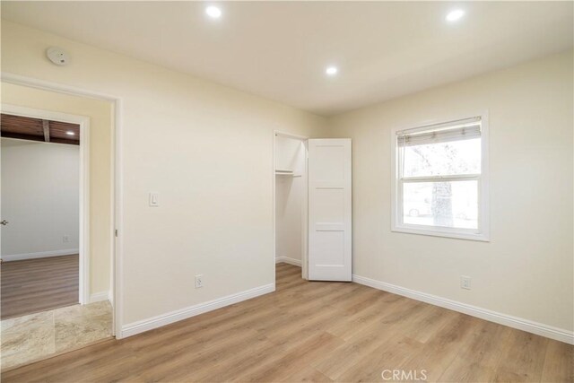 5402 N Fairvalley Ave, Covina, CA 91722 - unfurnished bedroom with light wood finished floors, a walk in closet, recessed lighting, and a closet