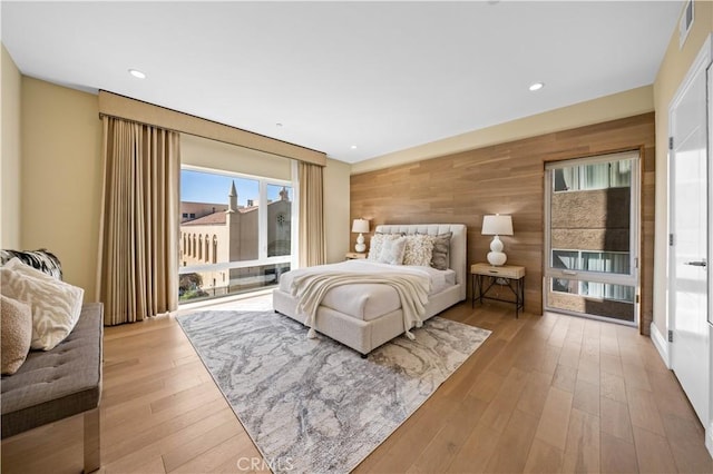 2939 Leeward Ave Unit 415, Los Angeles, CA 90005 - bedroom with access to exterior, wood walls, light wood-style flooring, and recessed lighting