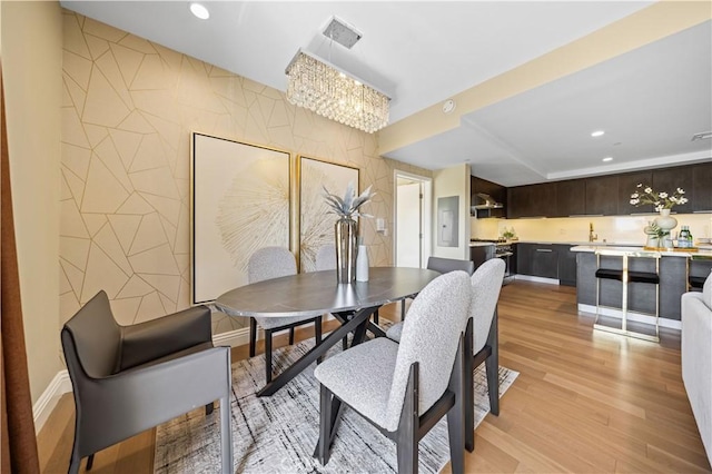 2939 Leeward Ave Unit 415, Los Angeles, CA 90005 - dining room featuring light wood-type flooring, recessed lighting, an accent wall, and a chandelier