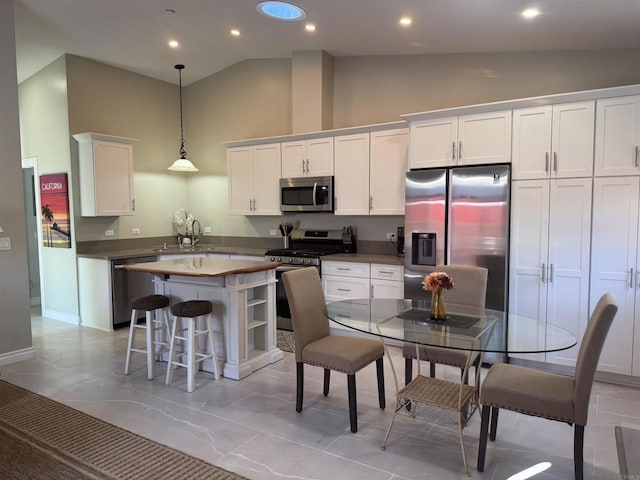 1139 Prussian, Oceanside, CA 92057 - kitchen with stainless steel appliances, high vaulted ceiling, a kitchen island, white cabinets, and pendant lighting