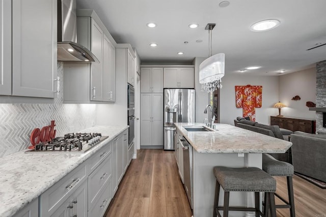 1139 Prussian, Oceanside, CA 92057 - kitchen with wall chimney range hood, appliances with stainless steel finishes, open floor plan, a breakfast bar area, and decorative backsplash