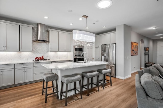 1139 Prussian, Oceanside, CA 92057 - kitchen featuring stainless steel appliances, wall chimney exhaust hood, open floor plan, arched walkways, and tasteful backsplash