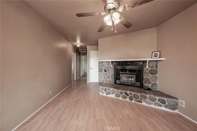 12410 Lakeview Dr, Clearlake Oaks, CA 95423 - unfurnished living room featuring baseboards, wood finished floors, a ceiling fan, and a fireplace