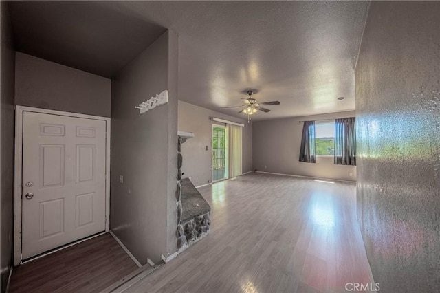 12410 Lakeview Dr, Clearlake Oaks, CA 95423 - unfurnished living room featuring wood finished floors, ceiling fan, baseboards, and a textured ceiling