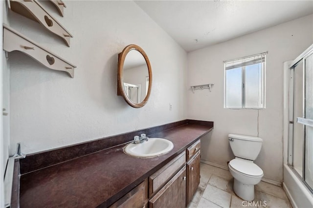 12410 Lakeview Dr, Clearlake Oaks, CA 95423 - full bathroom featuring vanity, toilet, tile patterned floors, baseboards, and combined bath / shower with glass door