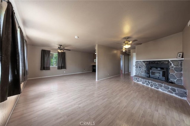 12410 Lakeview Dr, Clearlake Oaks, CA 95423 - unfurnished living room with a ceiling fan, a fireplace, light wood-style floors, and baseboards
