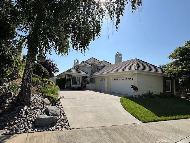 26433 Emerald Dove Dr, Valencia, CA 91355 - view of front of home with an attached garage, concrete driveway, a chimney, a tile roof, and a front lawn