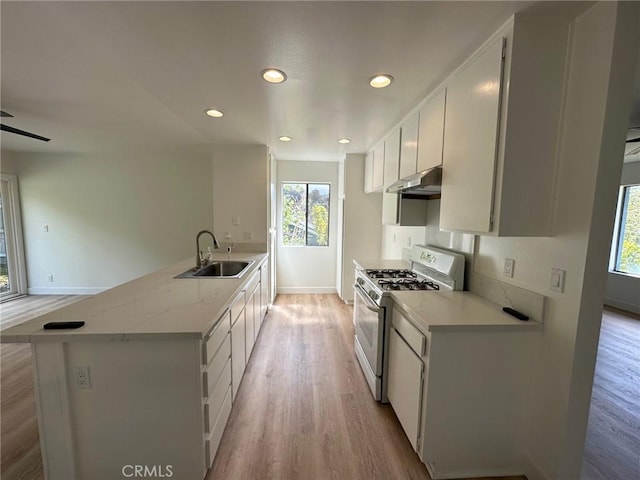 28802 El Canto Dr, Laguna Niguel, CA 92677 - kitchen featuring white gas range oven, under cabinet range hood, light wood-style flooring, a peninsula, and recessed lighting