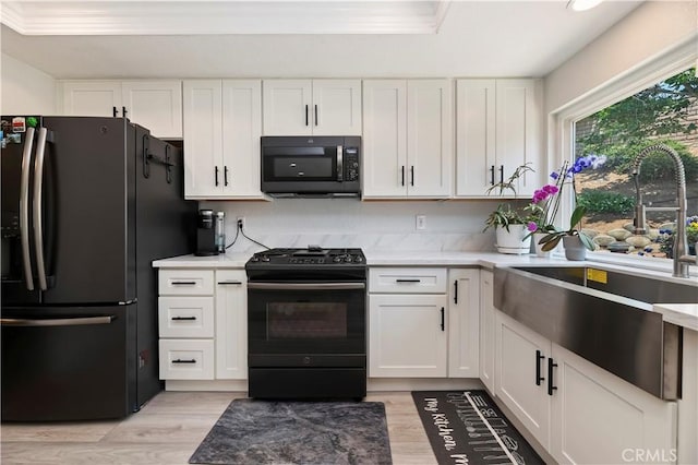 5996 Winncliff Dr, Jurupa Valley, CA 92509 - kitchen with black appliances, a sink, light countertops, white cabinets, and light wood-style floors