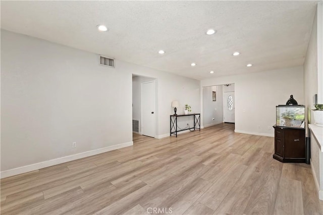5996 Winncliff Dr, Jurupa Valley, CA 92509 - unfurnished living room with recessed lighting, light wood-type flooring, baseboards, and a textured ceiling
