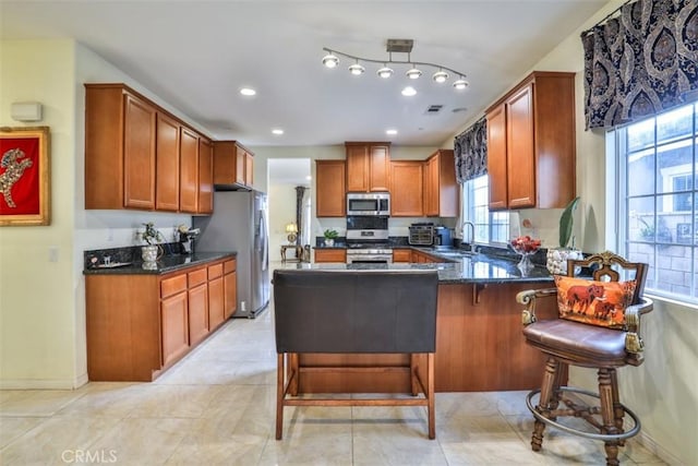13256 Garcia Ct, Rancho Cucamonga, CA 91739 - kitchen featuring appliances with stainless steel finishes, a peninsula, dark stone counters, recessed lighting, and a sink