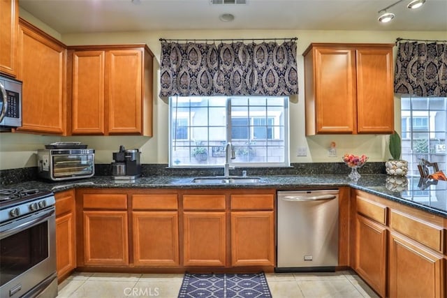 13256 Garcia Ct, Rancho Cucamonga, CA 91739 - kitchen featuring a sink, appliances with stainless steel finishes, dark stone countertops, and brown cabinets