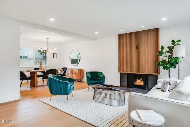 12938 Guadalajara Cir, Cerritos, CA 90703 - living area with wood finished floors, a chandelier, recessed lighting, a warm lit fireplace, and baseboards