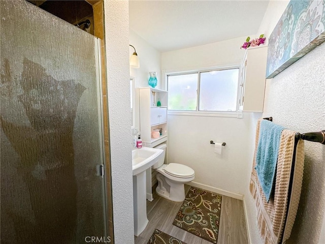 45439 Lorimer Ave, Lancaster, CA 93534 - bathroom with a stall shower, wood finished floors, toilet, and baseboards