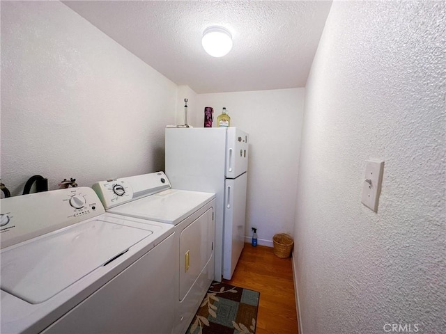 45439 Lorimer Ave, Lancaster, CA 93534 - laundry room featuring washer and clothes dryer, light wood-style flooring, a textured wall, and a textured ceiling