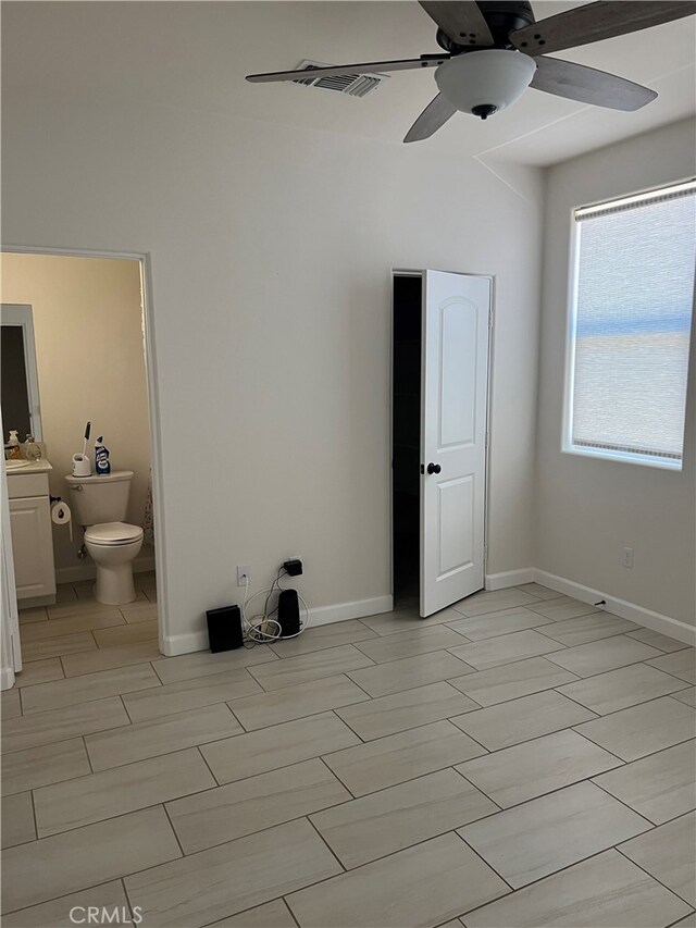 7448 Del Rio Vis, Yucca Valley, CA 92284 - unfurnished bedroom with ensuite bathroom, a ceiling fan, and baseboards