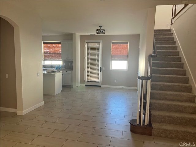 7448 Del Rio Vis, Yucca Valley, CA 92284 - foyer featuring stairway, arched walkways, baseboards, and light tile patterned floors