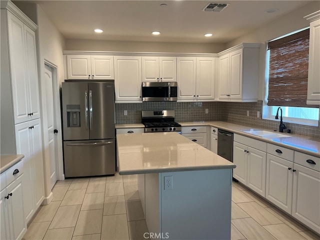 7448 Del Rio Vis, Yucca Valley, CA 92284 - kitchen featuring stainless steel appliances, a sink, white cabinetry, a kitchen island, and decorative backsplash
