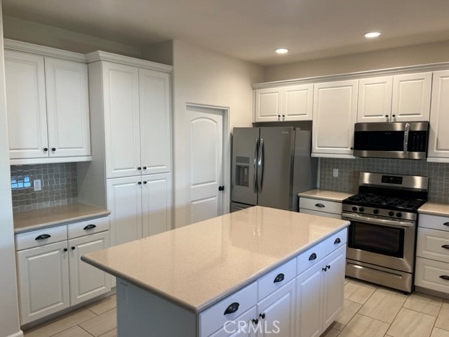 7448 Del Rio Vis, Yucca Valley, CA 92284 - kitchen with appliances with stainless steel finishes, light countertops, white cabinetry, tasteful backsplash, and recessed lighting