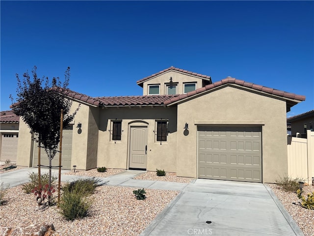 7448 Del Rio Vis, Yucca Valley, CA 92284 - mediterranean / spanish house featuring stucco siding, an attached garage, driveway, and a tiled roof