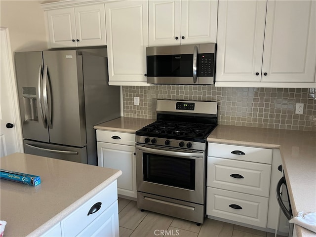7448 Del Rio Vis, Yucca Valley, CA 92284 - kitchen with appliances with stainless steel finishes, white cabinetry, and light countertops
