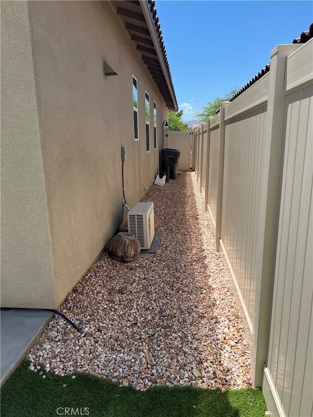 7448 Del Rio Vis, Yucca Valley, CA 92284 - view of property exterior with stucco siding, a fenced backyard, and a cooling unit