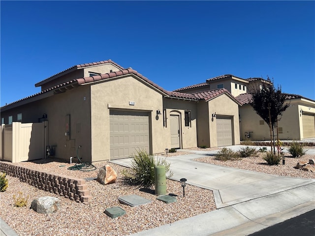 7448 Del Rio Vis, Yucca Valley, CA 92284 - mediterranean / spanish-style home with a garage, stucco siding, a tile roof, and concrete driveway