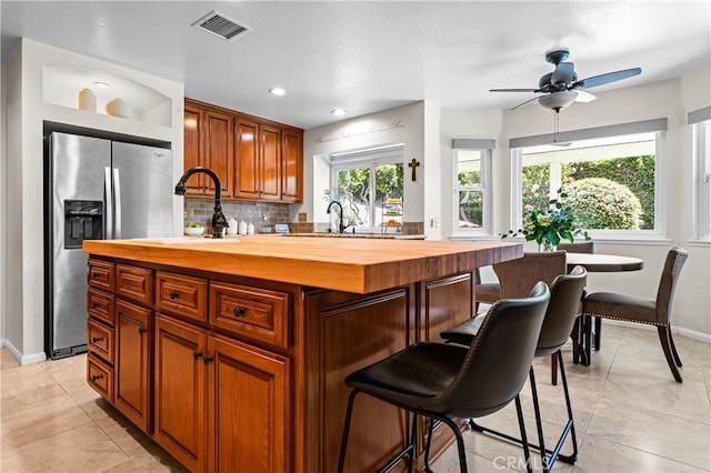 2074 Redgrove Way, Upland, CA 91784 - kitchen with wood counters, stainless steel refrigerator with ice dispenser, a breakfast bar, tasteful backsplash, and ceiling fan
