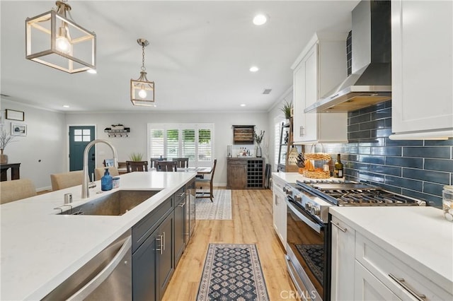 3848 Ocana Ave, Long Beach, CA 90808 - kitchen with wall chimney range hood, appliances with stainless steel finishes, light countertops, white cabinetry, and ornamental molding